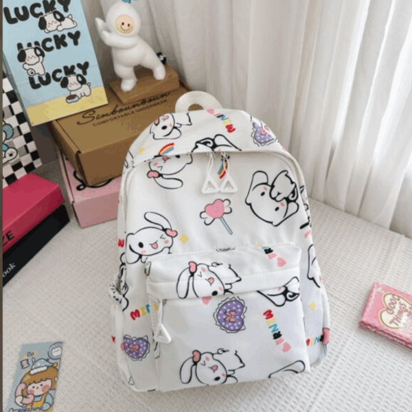 Minimalist white backpack decorated with an all-over print of Cinnamoroll expressions, pink lollipop accents, purple lace hearts, and triangular zipper pulls