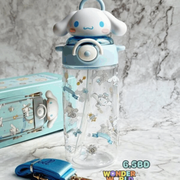 A crystal-clear drink bottle printed with soft blue and gold Cinnamoroll illustrations, topped with a custom-molded 3D cap depicting Cinnamoroll's face and floppy white ears, paired with a matching sky-blue adjustable woven shoulder strap
