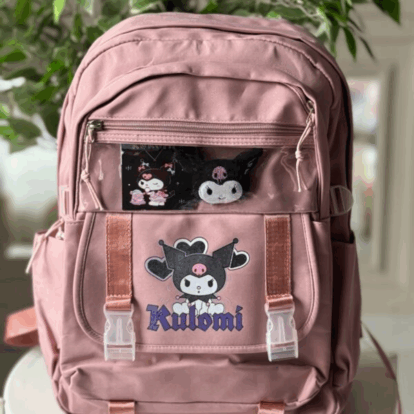 Muted dusty rose pink backpack featuring a Kuromi print with buckle flap and a clear top zippered display window with pins and plushies