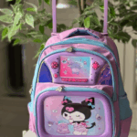Lilac and sky blue rolling backpack with a telescoping handle, featuring a 3D gaming console front compartment and a Kuromi graphic panel