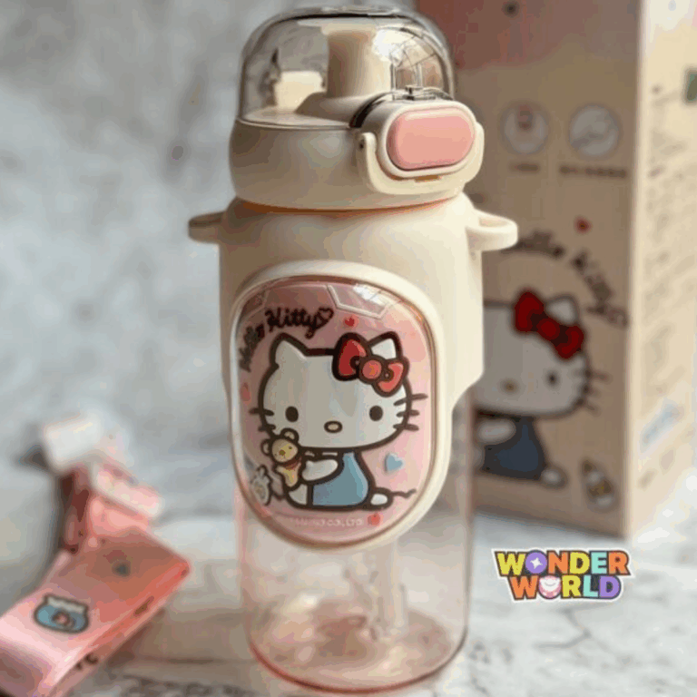 A clear drink bottle with a translucent pink bottom, a cream-colored top cap with a pastel pink pop-up locking button under a clear dome cover, wrapped in a cream silicone protective sleeve featuring a large oval plaque of Hello Kitty in her blue overalls holding a teddy bear, shown with its matching pink adjustable fabric shoulder strap