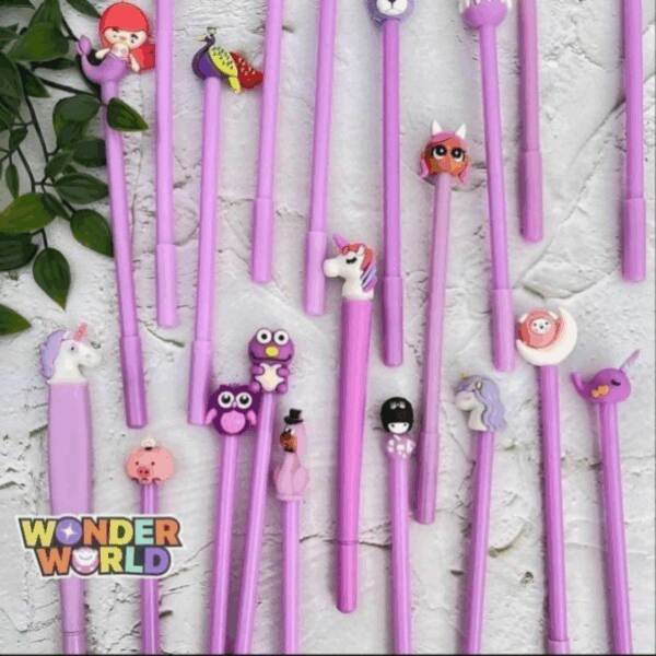 A collection of pastel purple gel pens spread across a textured white surface, each topped with a unique, colorful 3D silicone character, including a tiny mermaid, a majestic peacock, whimsical unicorns, a purple owl, a winking piglet, and a narwhal