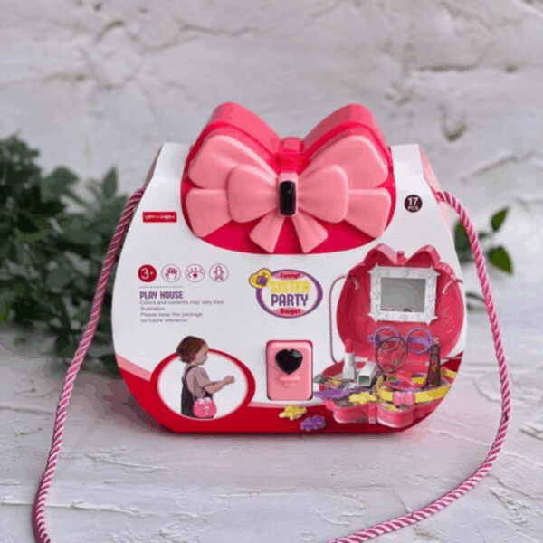 A structured hard-shell vanity case in vibrant fuchsia and pastel rose pink, showcasing an oversized layered pink bow clasp and a candy-stripe twisted shoulder strap, shown ready to pop open into a miniature pretend beauty salon
