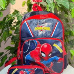 A premium school backpack and matching zippered utility case in deep midnight navy blue and athletic crimson red, showcasing a graphic geometric spiderweb pattern on the upper panel and a dynamic action-pose of Spider-Man on the lower front pocket