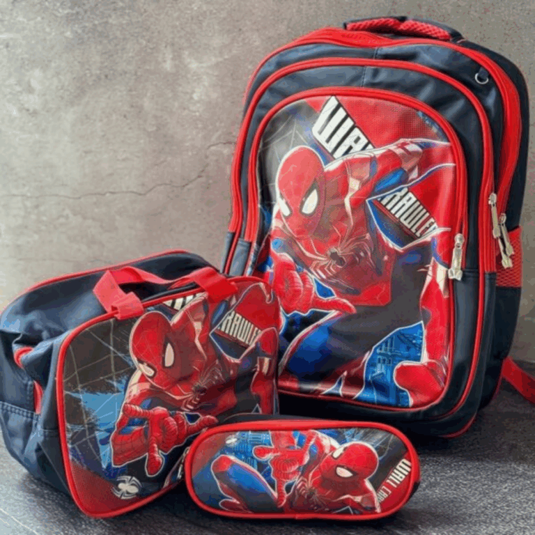 A premium three-piece school and travel set in deep charcoal black and bright crimson red, showcasing a dynamic graphic of Spider-Man in his gold-accented suit jumping in front of a sleek city skyline, complete with a backpack, matching lunch tote, and oval pencil case