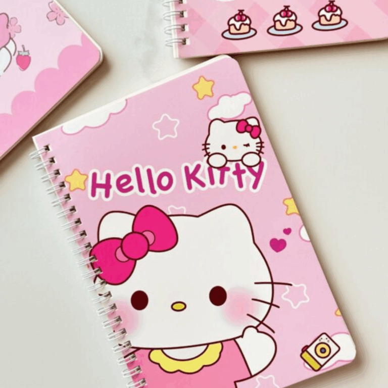 A close-up layout of a pink spiral notebook showcasing a large illustration of Hello Kitty with rosy cheeks and a bright magenta bow, surrounded by soft yellow stars, tiny hearts, and a vintage camera icon on a pastel background