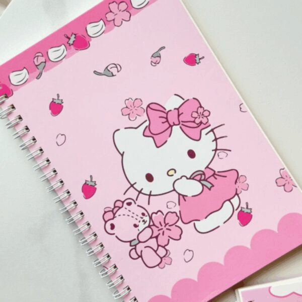 A delicate pink spiral-bound notebook featuring an elegant line-art illustration of Hello Kitty in a pink dress and matching bow, accompanied by her teddy bear amidst falling cherry blossom petals and mini strawberries